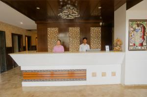 two people standing at a counter in a building at Hotel Yois in Udaipur