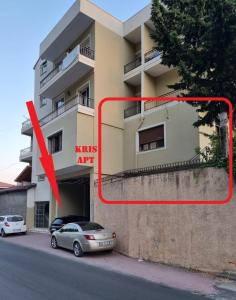 deux voitures garées devant un bâtiment dans l'établissement Kris's apartment, à Lezhë