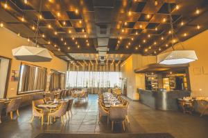 une salle à manger avec des tables, des chaises et des lumières dans l'établissement Hotel Yois, à Udaipur