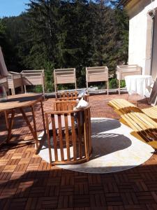 un patio avec des chaises, une table et un banc dans l'établissement Holzwerk Oybin, à Kurort Oybin