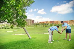 Golf Porto Marina Hotel Apartments Al Alamein في العلمين: رجلان يلعبان الغولف على ملعب للجولف