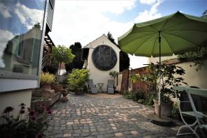 un patio con sombrilla frente a una casa en Ferienhaus anno 1895, en Schaafheim