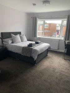 a bedroom with a bed and a large window at Sutton Park Lodge in Sutton Coldfield