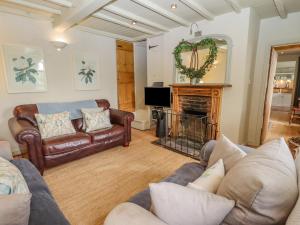 a living room with leather furniture and a fireplace at Jolls Cottage in Horncastle