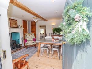 a living room with a table and chairs and a fireplace at Jolls Cottage in Horncastle