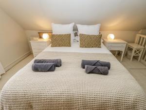 a bedroom with a large bed with two pillows on it at Jolls Cottage in Horncastle