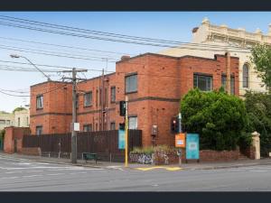 a red brick building on the corner of a street at Richmond Private Rooms - 151 Hoddle Homestay in Melbourne