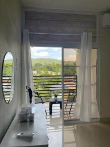 a living room with a view of a balcony at Balcón Skyline 2 in Jarabacoa