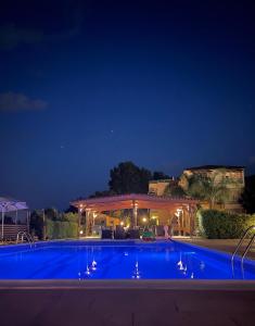 a large swimming pool at night with a pavilion at Hotel Afrika in Eleonas