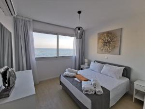 a bedroom with a bed and a large window at COSea Living: Seaside Two Bedroom Flat in Harbour 106 in Paphos City