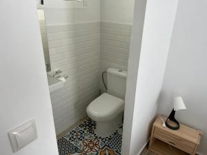 a bathroom with a toilet and a tile floor at Alzira bonita Apartamento B con patio, la Casella in Alzira