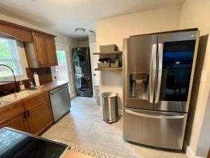 a kitchen with a large stainless steel refrigerator at Hidden Gem! The Hogspitality House - 3 Bedroom - 5 min from the University of Arkansas! in Fayetteville