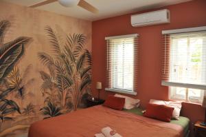 a bedroom with a bed and a wall with plants at Casa Makoshi Bonaire in Kralendijk