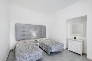 a bedroom with two beds and a dresser and a mirror at Casa Micaela 1 in Tacoronte