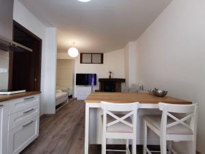 uma cozinha com uma mesa e duas cadeiras brancas em Monolocale - Piano terra - Ingresso indipendente em Pádua