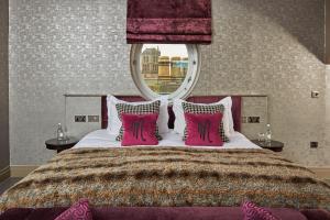 a bedroom with a bed with a red and white bedspread at Malmaison Dundee in Dundee
