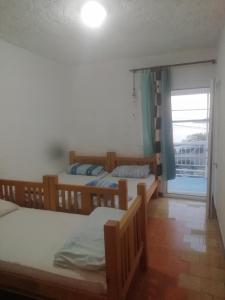 1 Schlafzimmer mit 2 Etagenbetten und einem Fenster in der Unterkunft PLAVOBELA KUĆA SA MAGIČNIM POGLEDOM NA MORE in Herceg-Novi