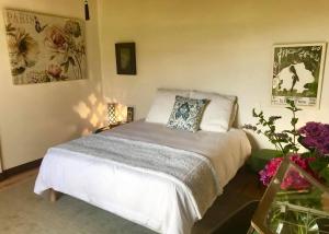a bedroom with a bed with a pillow and flowers at Maison chulubitenia in Irouléguy