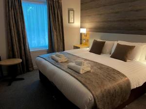 a bedroom with a large bed with towels on it at Craiglynne Hotel in Grantown on Spey
