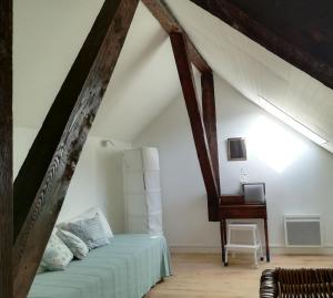 sypialnia na poddaszu z łóżkiem i biurkiem w obiekcie Appartement chaleureux, montagne et cures w mieście Argelès-Gazost