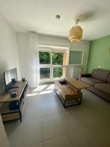 a living room with a couch and a coffee table at Studio rénové proche commodités in Pessac