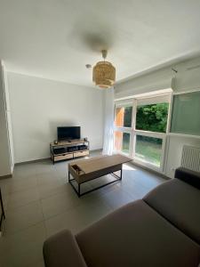 a living room with a couch and a coffee table at Studio rénové proche commodités in Pessac