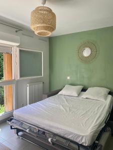 a bedroom with a large bed with a green wall at Studio rénové proche commodités in Pessac