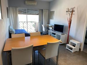 a dining room with a table and chairs and a television at Bernardita in Ramos Mejía