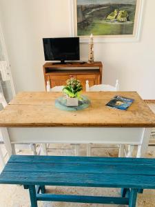 una mesa de madera con un banco azul y una mesa con una planta en CASA AL MARE RIO b&n, en Tricase