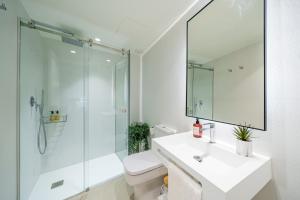uma casa de banho branca com um lavatório e um chuveiro em Homely Málaga Mariblanca 17, Vegafuente Apartments em Málaga