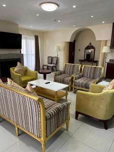 a living room with couches and chairs and a table at Open House Hotel in Mbabane