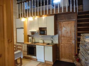 a small kitchen with white cabinets and a sink at Rukansyli 2 in Ruka