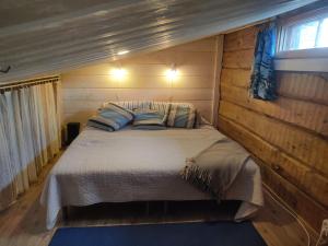 a bedroom with a bed in a wooden cabin at Rukansyli 2 in Ruka