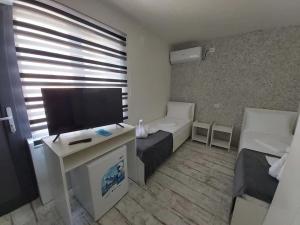uma pequena sala de estar com televisão e sofá em AmA em Constança