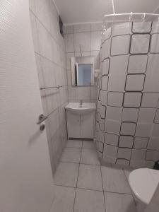 uma casa de banho em azulejos brancos com um WC e um lavatório em AmA em Constança