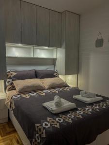 a bedroom with a bed with two towels on it at Apartman ML in Lukavica