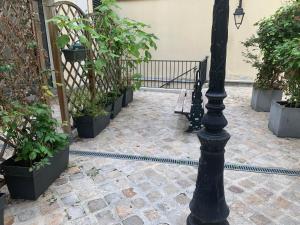 a black lamp post in a courtyard with plants at BEST CENTRAL Chambres Privées - Seine & Louvre in the Connected Heart of Paris in Paris