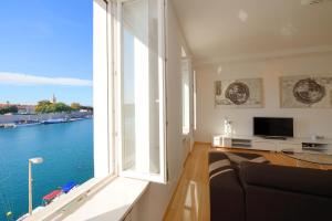 una sala de estar con una gran ventana con vistas al agua en Eden Penthouse Apartments, en Zadar