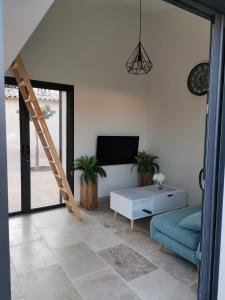 a living room with a couch and a tv and a ladder at Studio en campagne in Avignon