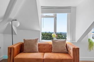 un sofá naranja en una sala de estar con ventana en 2 Bed- The Penthouse By Pureserviced, en Plymouth