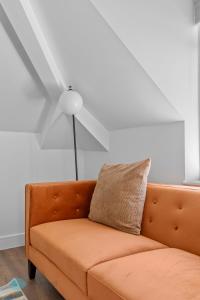 an orange couch in a living room with a ceiling fan at 2 Bed- The Penthouse By Pureserviced in Plymouth