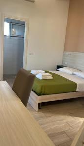 a bedroom with a bed with a green blanket at KARIS KAIROS in Santa Maria di Castellabate