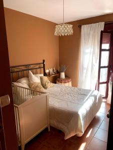 - une chambre avec un lit et une fenêtre dans l'établissement Casa situada en un entorno natural Casa Rural La Serena, à Trujillo