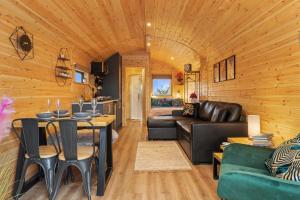 a living room with a couch and a table at Blaenplwyf Luxury Countryside Shire Pods with Hot Tubs in Lampeter