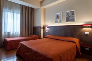 a hotel room with two beds and a window at Hotel Centrale in Mestre