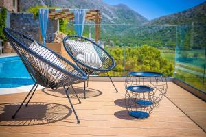 a pair of chairs andools on a deck with a pool at Traditional Villa Askyfou in Karés