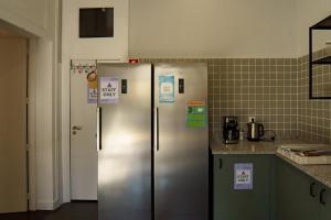 a kitchen with two stainless steel refrigerators with signs on them at Rosalma Hostel in Porto