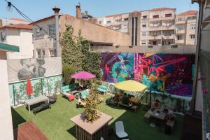 an overhead view of a rooftop patio with a mural at Rosalma Hostel in Porto