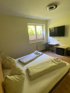um quarto de hotel com uma cama e uma televisão em Hotel Seestuben em Villach