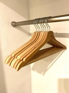 a wooden hanger in a room with a wall at Studio Exotique Hyper-Centre Enghien 12min Paris in Enghien-les-Bains